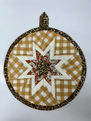 Round Scrappy Potholder with gold gingham, a cream star, and leopard-print binding