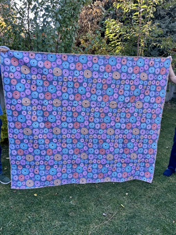 Reverse view of Anna’s Quilt with colorful circular motifs in pink, purple, blue, and turquoise