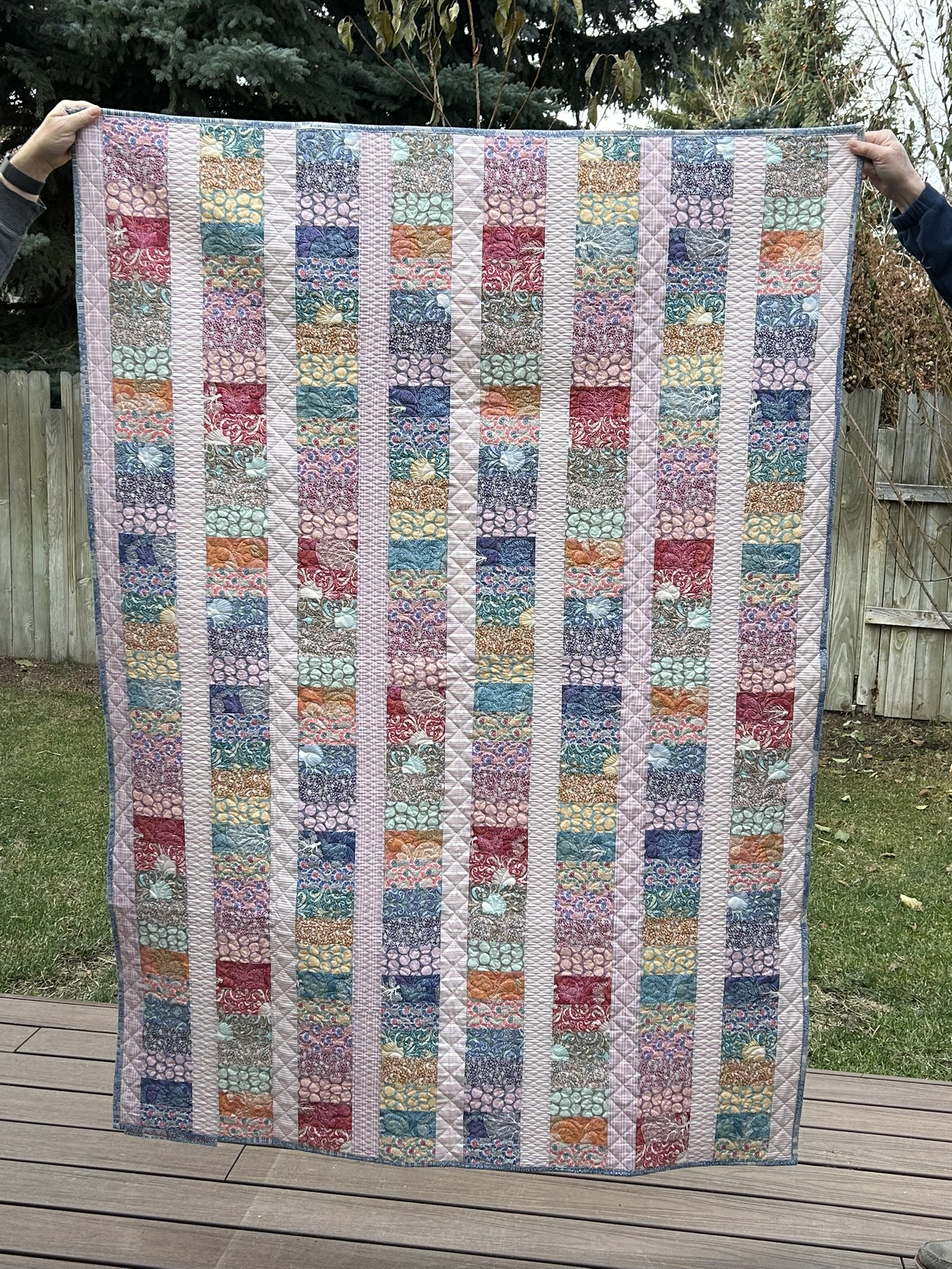 Full front view of Libby’s Quilt by Michele Urbany Neely Puluti with vertical floral fabric columns and pale geometric separators