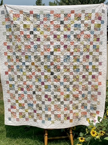 Full view of Michele Urbany Neely Puluti’s Squares Quilt with multicolored fabric squares on white