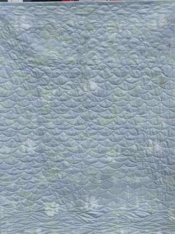 Reverse side of Hedgehog Goes to the Beach showing densely quilted waves and clouds