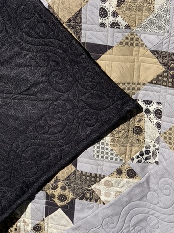 Dark reverse and patterned front detail of the Pam and Jack quilt showing intricate quilting