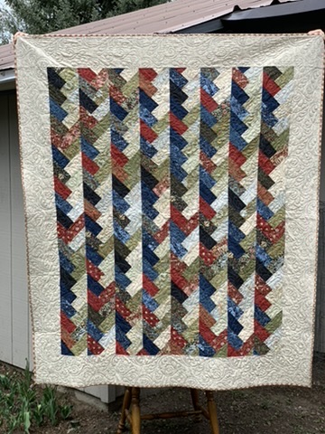 Full view of Michele Urbany Neely Puluti’s Friendship Braids Quilt with interlocking multicolored fabric braids