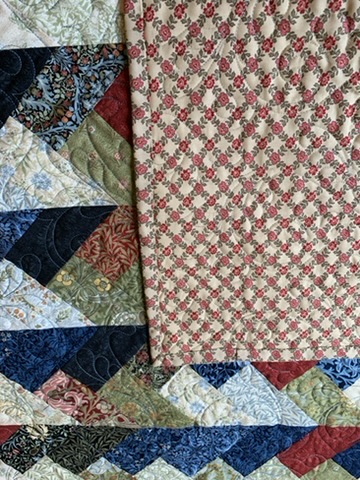 Close view of Friendship Braids Quilt showing braided patchwork, binding, floral backing, and quilting
